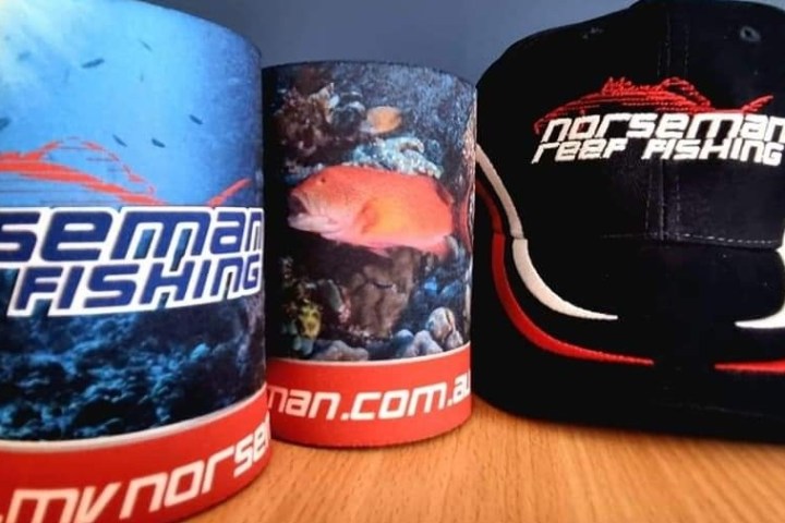 rolled up t-shirts and a cap on a table