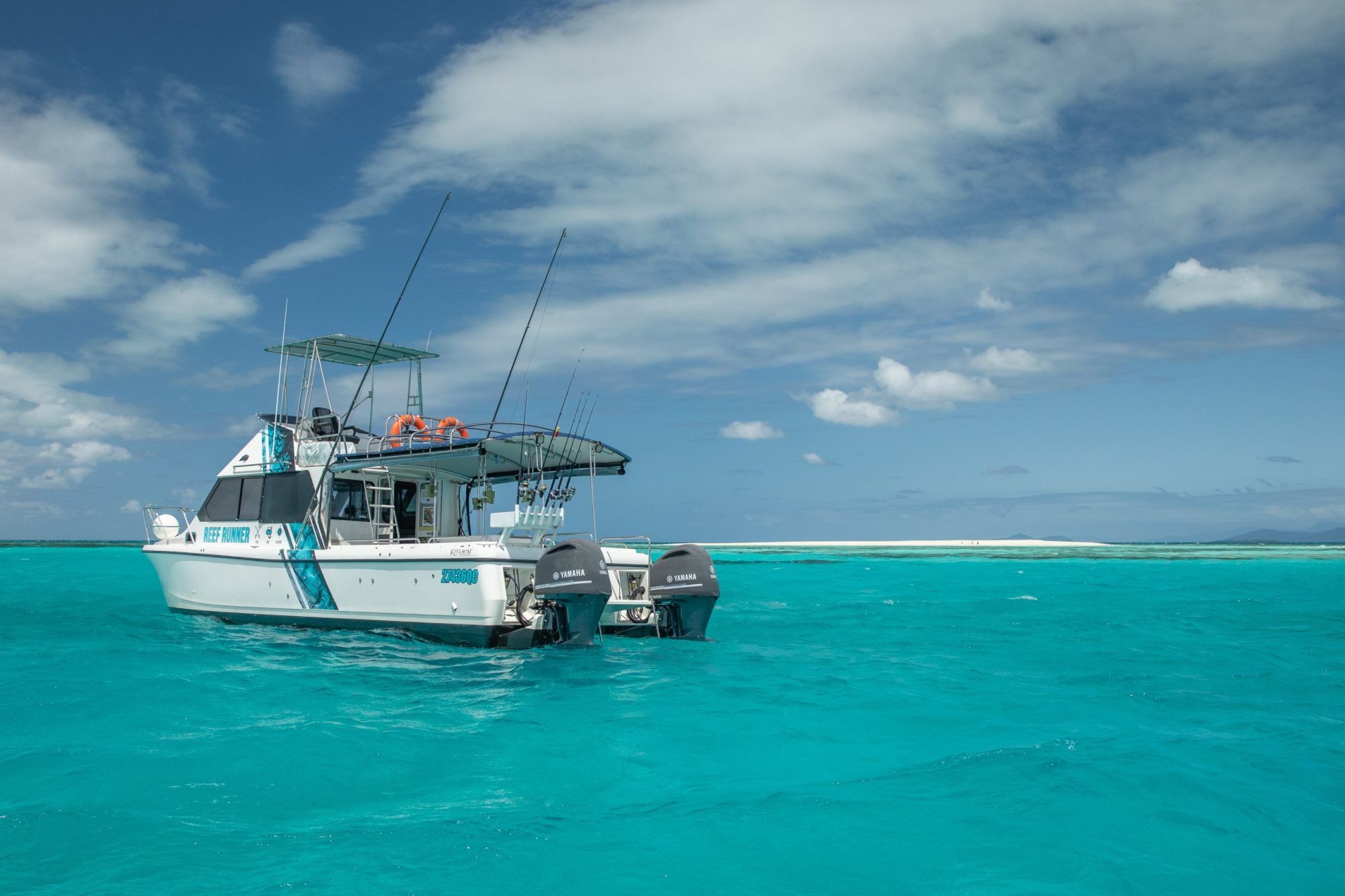 Motorboat on turquoise sea with clear sky and distant horizon.
